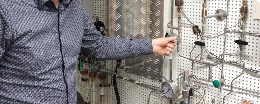 Professor Pär Olsson visar ugnen som når upp till 2000 grader, i vilken man tillverkar kärnbränslepulver. Här sker omvandlingen från uranmetall till uranhydrid (med tillförsel av vätgas) och till urannitrid (med tillförsel av kvävgas). Bild: Städje.