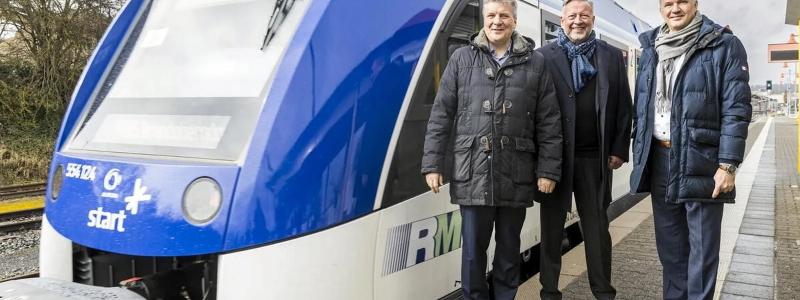 Tyska kollektivtrafikbolaget satsar på tillfälliga lösningar för RB15-linjen. Rhein-Main-Verkehrsverbund (RMV) står inför en utmanande period när bränslecellsdrivna tåg på RB15-linjen ersätts med dieseldrivna enheter under hela 2025. På bilden ses RMV:s styrelseordförande Ulrich Krebs, verkställande direktör Knut Ringat och Usingens borgmästare Steffen Wernard vid Usingen station tillsammans med ett tåg från RB15-linjen. 
De bränslecellsdrivna tågen, som infördes för att minska beroendet av fossila bränslen, har visat sig vara opålitliga under sina två första år i drift. Det har lett till omfattande trafikstörningar och nödlösningar med dieseldrivna tåg. RMV arbetar nu med tillfälliga lösningar för att säkerställa stabil trafik för passagerarna på linjen. Foto: Arne Landwehr/RMV
