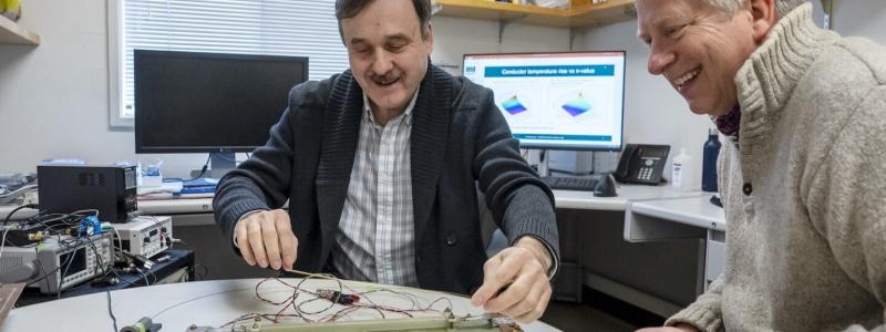 Forskarna Maxim Marchevsky (till vänster) och Soren Prestemon diskuterar en experimentell uppställning för att testa känsligheten hos ett temperaturövervakningssystem för en högtemperatursuperledande magnet. Foto: Marilyn Sargent/Berkeley Lab.