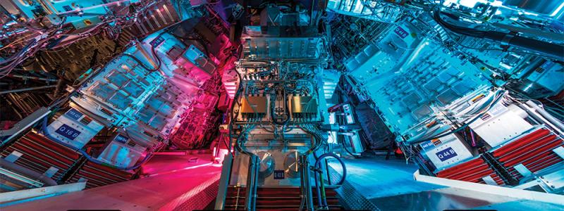 (Ovan) En vy från Target Bay av några av de slutliga optikenheterna som omger NIF Target Chamber, platsen för NIF:s tröghetsinneslutningsfusionsexperiment. (Nedan) Illustration av stadierna av en ICF-implosion. Fotokredit: Jason Laurea; bildkredit: Brian Chavez