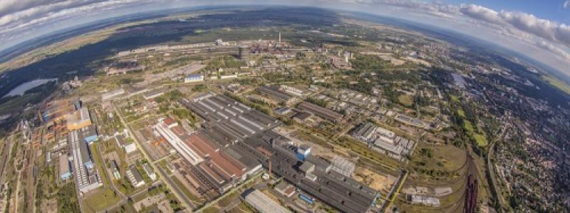 ArcelorMittal från ovan. Denna världens näst största stålproducent, som planerat att investera 2,5 miljarder euro för att avkarbonisera sina tyska stålanläggningar - en satsning som nu står på osäker grund. Foto: ArcelorMittal Eisenhüttenstadt