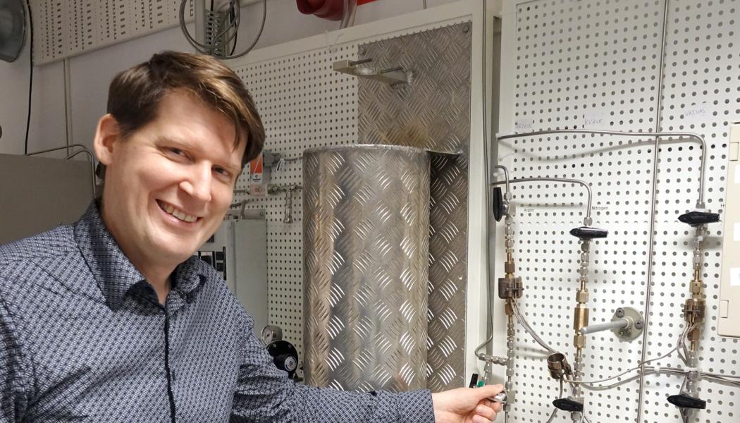 Professor Pär Olsson visar ugnen som når upp till 2000 grader, i vilken man tillverkar kärnbränslepulver. Här sker omvandlingen från uranmetall till uranhydrid (med tillförsel av vätgas) och till urannitrid (med tillförsel av kvävgas). Bild: Städje.