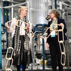 Malin Frenning, vd RISE och Anna-Britta Åkerlind, kommunstyrelsens ordförande i Örnsköldsvik kopplar ihop en symbolisk värdekedja vid invigningen av RISE nya pilothall för bioraffinaderi. Foto: RISE
