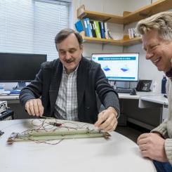 Forskarna Maxim Marchevsky (till vänster) och Soren Prestemon diskuterar en experimentell uppställning för att testa känsligheten hos ett temperaturövervakningssystem för en högtemperatursuperledande magnet. Foto: Marilyn Sargent/Berkeley Lab.
